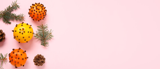Pomander balls, Christmas tree branches and cones on pink background with space for text, top view