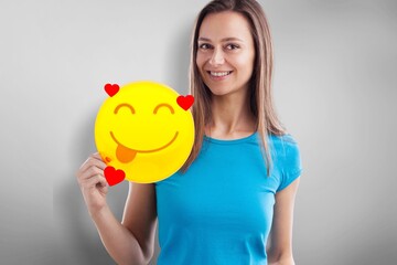 Love Emoticon. Girl holds a smiley face