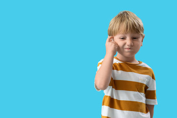 Thoughtful little boy on blue background