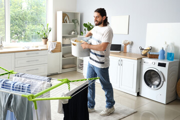 Young man with laundry basket at home