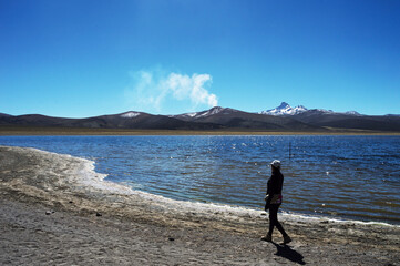 young woman walking next to lake huañacota
