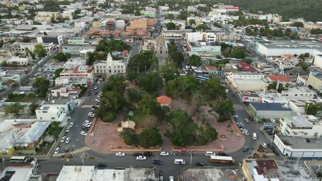Aerial view of the central park of La Romana in the Dominican Republic in the afternoon where you can see the Catholic church and the city hall and the statue of the father of the country.