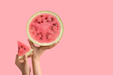 Female hands with half and slice of ripe watermelon on pink background