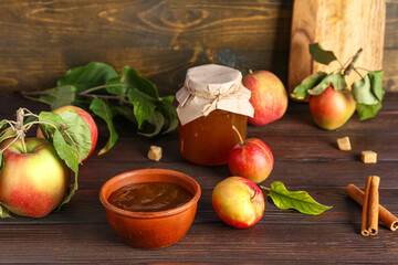 Bowl of apple jam, fresh fruits and spices on wooden table