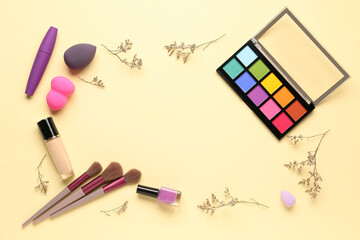 Frame made of makeup products and beautiful flowers on beige background