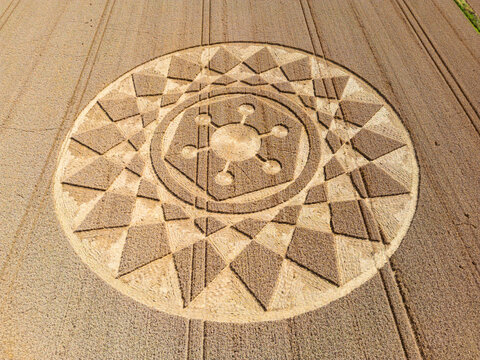 Aerial view of an intricate geometric crop circle formation in a wheat field in Wiltshire, England, UK