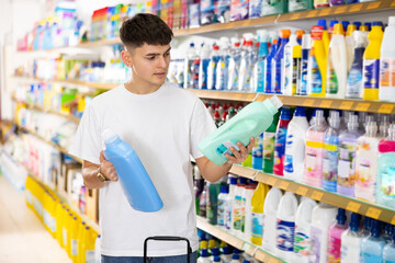 Young man looking to buy laundry detergent in supermarket