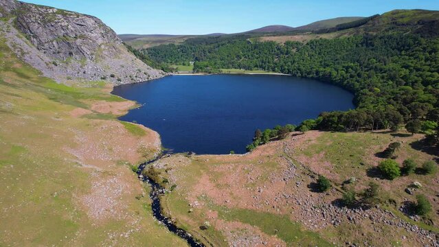 IRELAND - JULY.27.2023 - Excellent aerial footage moving over an inlet towards Lough Tay Lake in Wicklow, Ireland.