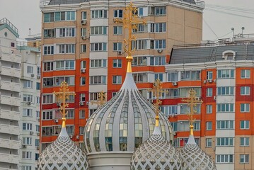 Domes of the church against residential building, close up