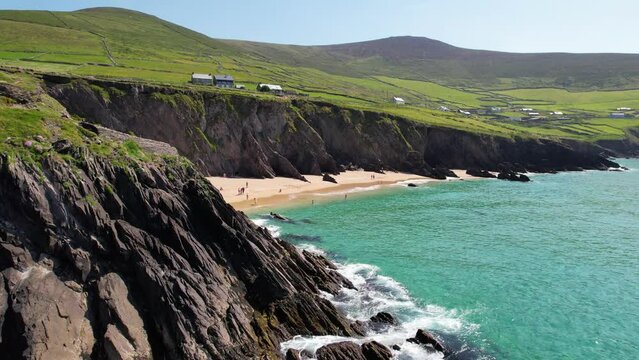 IRELAND- 8.27.2023 -Excellent aerial footage moving towards tourists on the beach in Dingle, Ireland.