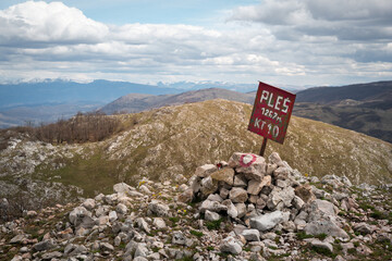 Summit Ples marking on Svrljig mountains with snow covered Stara planina (Balkan mountain) in the background - 671280782