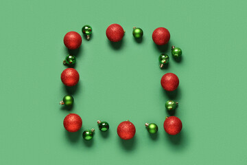 Frame made of different Christmas balls on green background