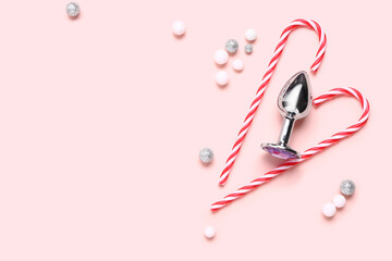 Anal plug from sex and tasty candies for Christmas celebration on pink background