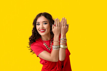 Beautiful happy Indian woman in sari on yellow background