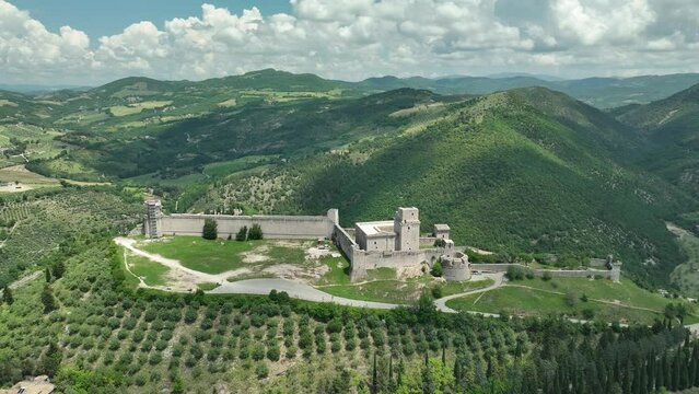 ITALY - AUGUST.9.2023 - Excellent aerial footage circling the Basilica of Saint Francis of Assisi in the mountains of Assisi, Italy.