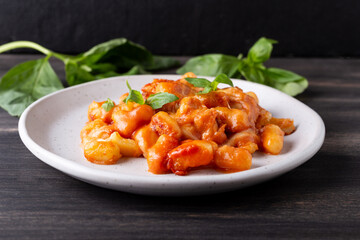 Gnocchi with tomato sauce, mozzarella cheese and basil. Italian traditional food.