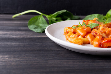 Gnocchi with tomato sauce, mozzarella cheese and basil. Italian traditional food.