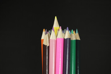Drawing equipment, wooden colored pencils, isolated on black background
