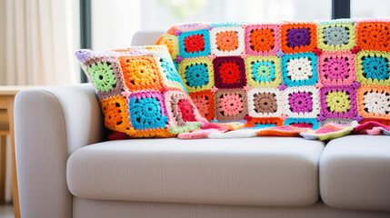 Close up of cozy crochet blanket lying on sofa, cute textile knitted accessories for comfy home. 