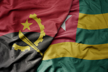 big waving national colorful flag of angola and national flag of togo .