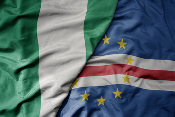 big waving national colorful flag of nigeria and national flag of cape verde .