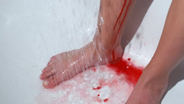 A girl with menstruation. A girl washes blood from her feet in the bathroom.