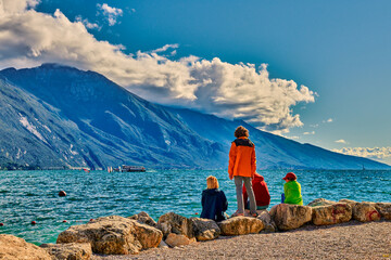 People admiring Lake Garda in autumn time,Garda lake surrounded by mountains, Trentino Alto Adige...