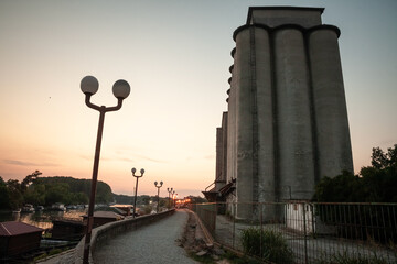 Panorama of the Tamis river, on Pancevo Waterfront in the center of the city, during a warm summer sunset. Iconic silos are visible in front. Pancevo, Serbia, is one of the biggest cities of banat.