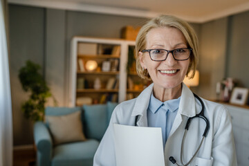 Portrait of one mature blonde caucasian woman doctor medic home visit