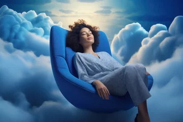 Fotobehang A young African American woman enjoys restful sleep while sitting in an armchair surrounded by clouds. After a good night's sleep, we are more productive, think clearly, and make better decisions © SnapVault