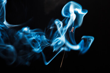 Smoke from incense stick on a black background with copy space