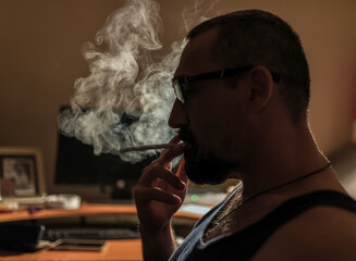Handsome young man smoking cigarette