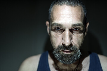 Close up of sad man in dark room. Depression and anxiety disorder concept.