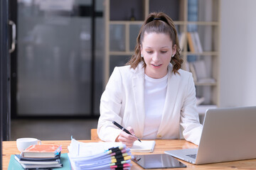 Businesswoman working in front of a laptop in the office.
