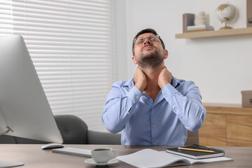 Obraz premium Man suffering from neck pain in office