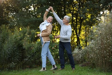 Fototapeta premium Affectionate senior couple dancing together in park. Romantic date