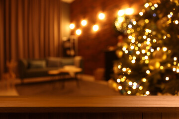 Empty wooden table in room decorated for Christmas, festive blurred interior. Space for design