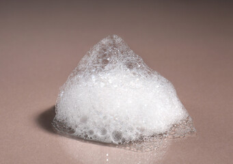 Foaming cleanser on brown background. Skin care cosmetic