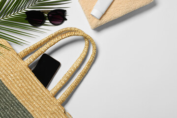 Flat lay composition with wicker bag, palm leaf and other beach accessories on white background. Space for text