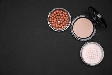 Different face powders on black background, flat lay. Space for text