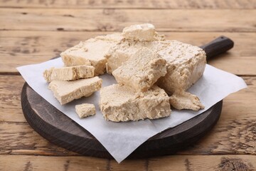Pieces of tasty halva on wooden table