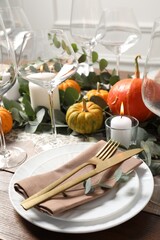 Beautiful autumn table setting. Plates, cutlery, glasses, pumpkins and floral decor