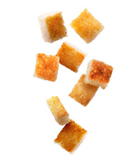 Delicious crispy croutons falling on white background