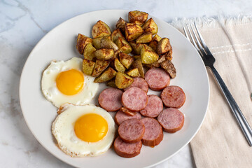 fried eggs  with sliced kielbasa  and home fries