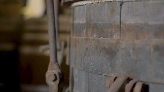 Rusty iron details of old wooden wine barrel, made of oak, seen on a close up, slow motion camera movement. Aged for decades on a wine house at a traditional winery 