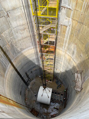 Lift the drill head of tunnel boring machine  into the construction shaft  using a crane. Engineer...