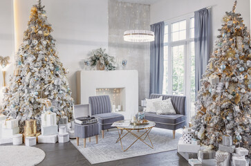 Luxurious classic interior of the living room with a vinyl player, sofa, armchair, table, fireplace, decorated snowy Christmas tree with gifts with lights and balls in beige, gold and silver