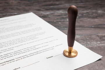 One stamp tool and document on grey marble table, closeup