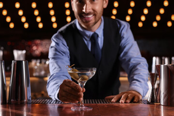 Bartender with fresh alcoholic cocktail in bar, selective focus