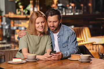 Fototapeta na wymiar Romantic date. Lovely couple spending time together in cafe